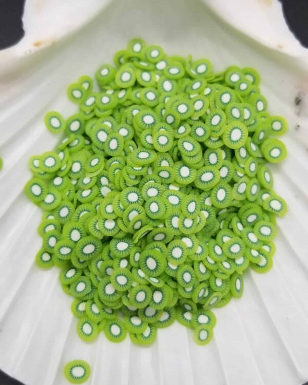 A pile of green beads sitting on top of a white plate.