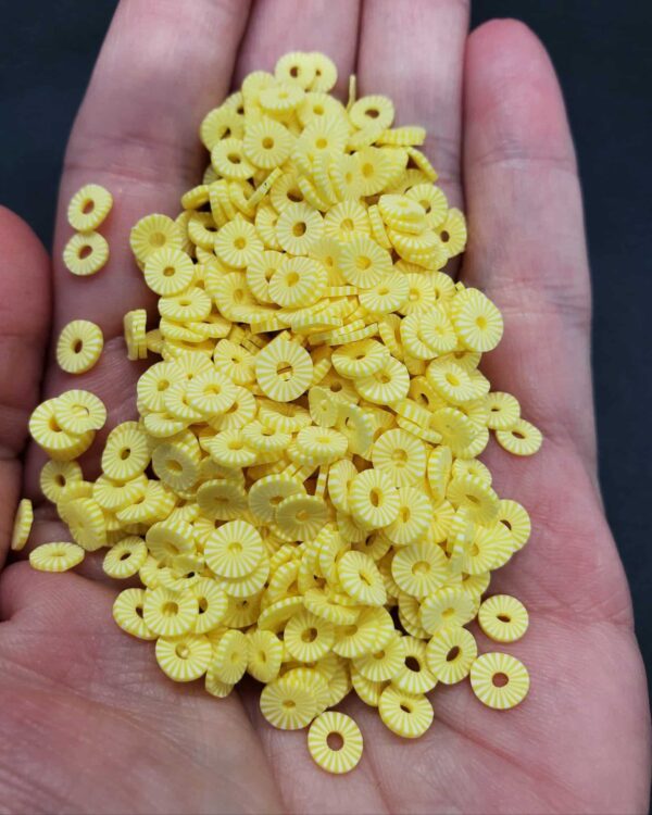 A hand holding some yellow cereal in it