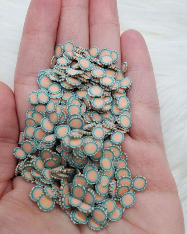 A hand holding a bunch of small blue and orange flowers.