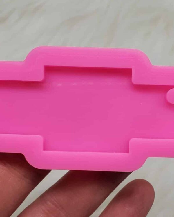 A pink plastic container with a small bow tie design.