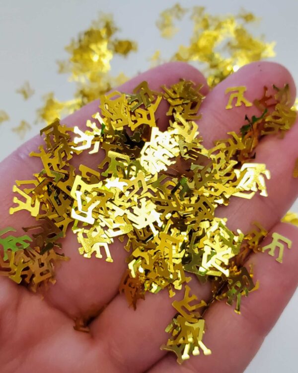 A hand is holding some gold confetti