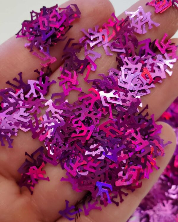 A hand filled with purple and pink confetti.