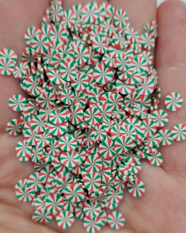 A hand full of peppermints in red and green.