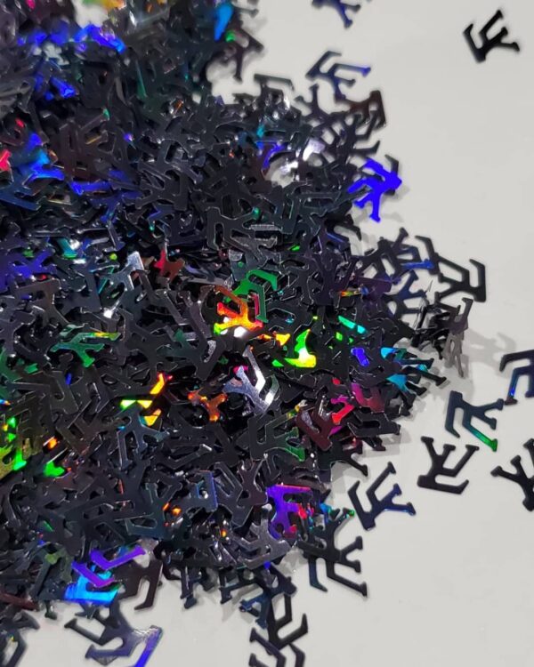 A pile of black confetti with colorful shapes on it.