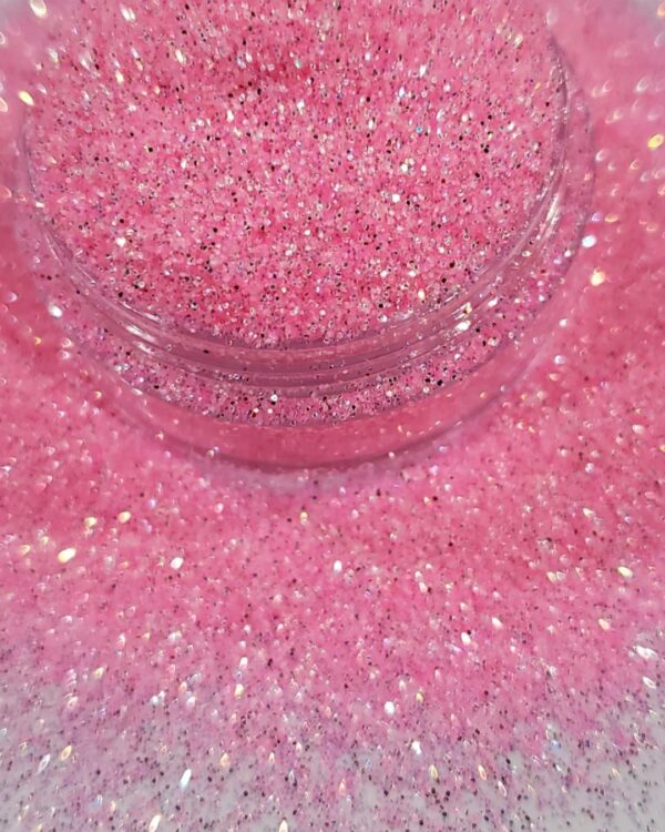 A jar of pink glitter on top of a table.