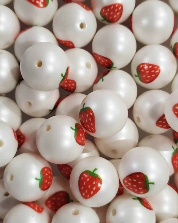 A pile of white beads with strawberries on them.