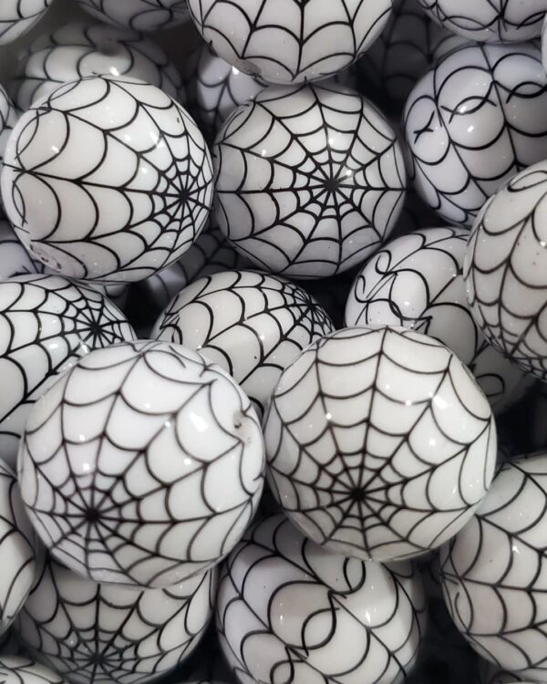 A pile of white balls with black spider webs on them.